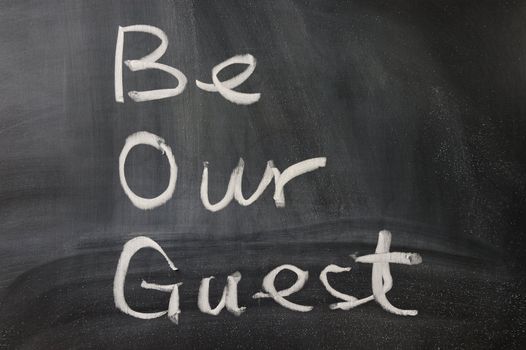 Be our guest words written  on the blackboard