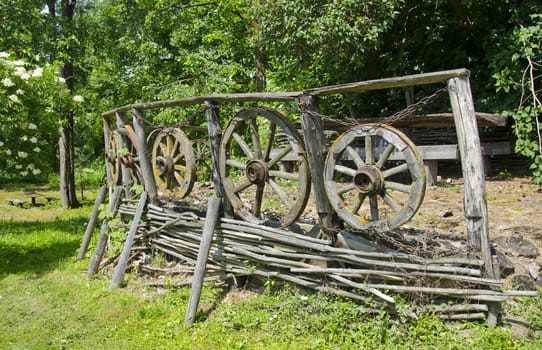 vintage wooden fence with carriage wheels in farm