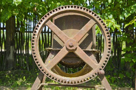 old and rusted agriculture metal wheel in garden