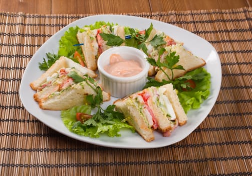 Canape with ham and egg and cup of sauce. closeup