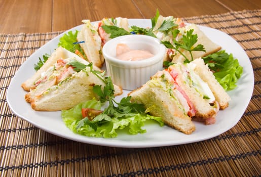Canape with ham and egg and cup of sauce. closeup