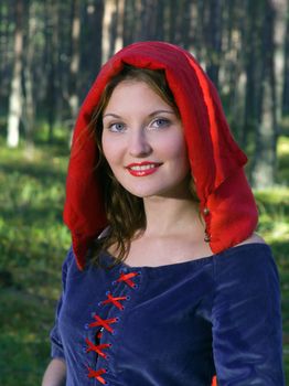 red Riding  hood standing in a wood . beautiful girl in medieval dress