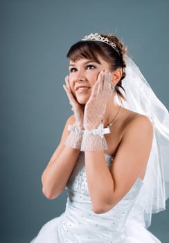 Beauty young bride dressed in elegance white wedding dress  gray studio background 