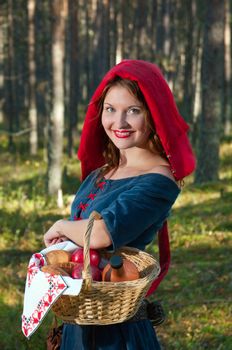 red Riding  hood standing in a wood . beautiful girl in medieval dress