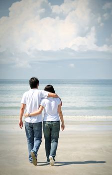 romantic couples walking together on the beach