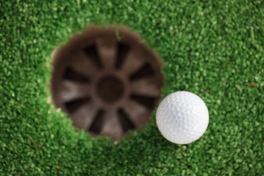 golf ball on lip of cup (Selective focus at golf ball)