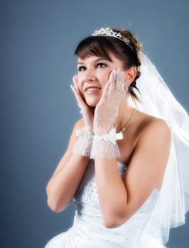 Beauty young bride dressed in elegance white wedding dress  gray studio background 