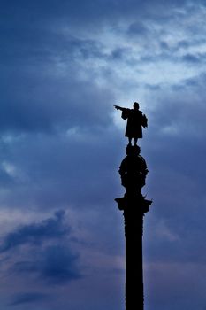 a silhouette of the statue of Columbus in Barcelona