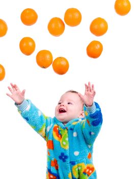 Little baby girl caughts flying oranges  orange .isolated on white background