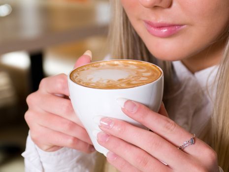  young woman holding a cup of hot drink.Shallow depth-of-field. 
