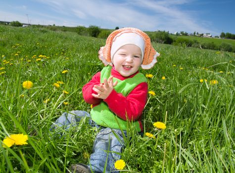 small girl  on meadow with dandelion