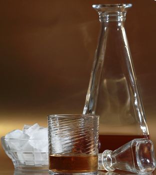 a glass of whiskey and the elegance bottle