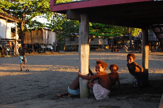 Children smiling near house in Papua New Guinea village