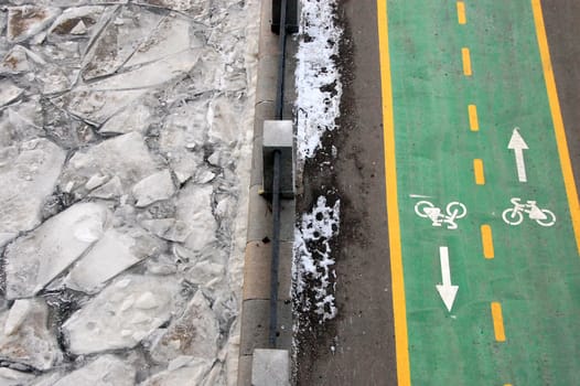 Green bicycle path at winter riverside road, Moscow, Russian Federation