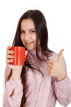 Woman holding a cup of delicious coffee showing Ok
