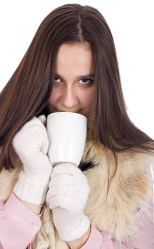 Woman in winter clothes and white gloves, drinking tea and warmed