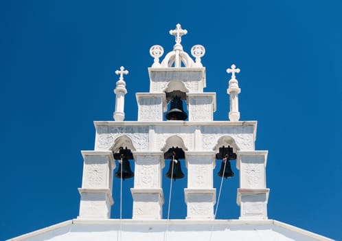 White Bell Tower against blue Sky in Greece
