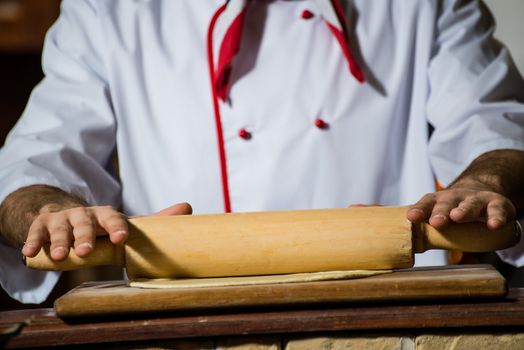 Cook rolls out the dough on a board, the traditional cooking