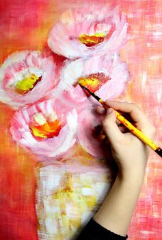 Artist�s hand holding a paintbrush and paints beautiful picture