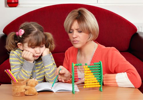 unhappy daughter and mother doing homework