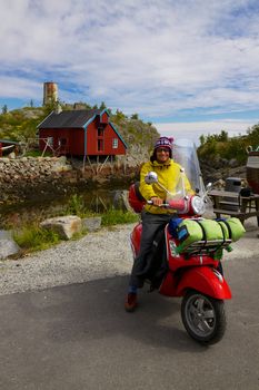 Young adventurer sitting on scooter traveling in Scandinavia