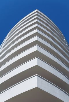 white balconies of a modern residential building on a clear blue sky