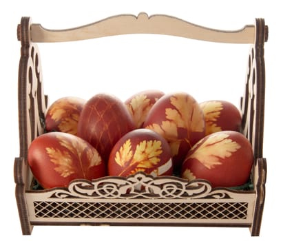 Easter eggs in a decorative basket on a white background