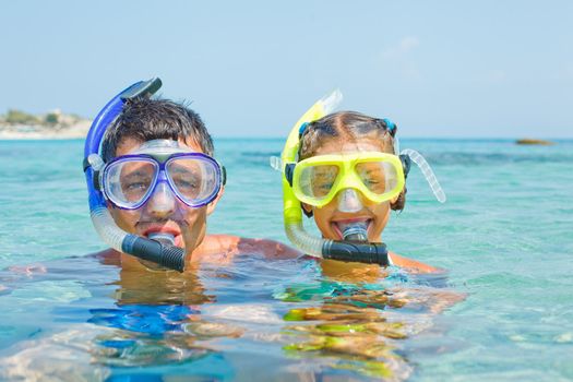 Cute girl with her father snorkelling swimming in the transparent sea