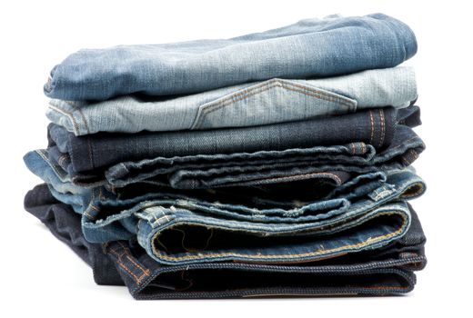 Stack of Folded New Dark and Light Blue Jeans isolated on white background