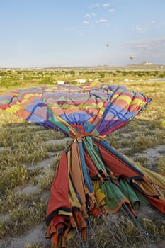 vertical landscape of a group of roadies packing away a hot air balloon after a passenger flight. Generic shot location Cappadocia Turkey