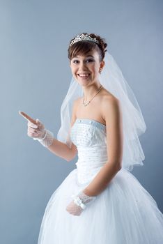 Beauty young bride dressed in elegance white wedding dress  gray studio background 