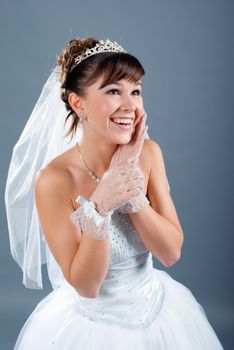 Beauty young bride dressed in elegance white wedding dress  gray studio background 