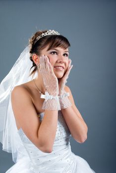 Beauty young bride dressed in elegance white wedding dress  gray studio background 