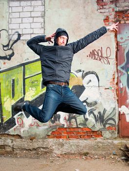 cool looking dancer posing on a grunge background with graffiti 