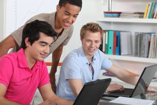 Young students working on their laptops in the university library