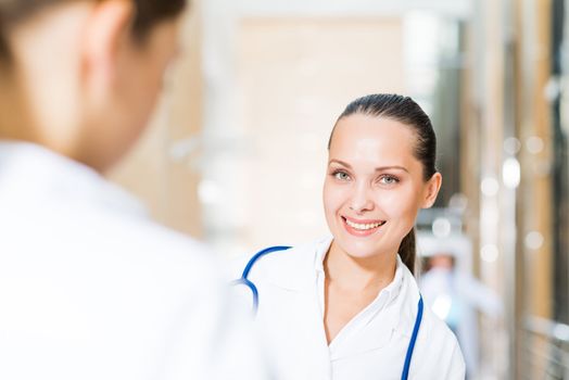 two doctors talking in the lobby of the hospital, sitting on the couch