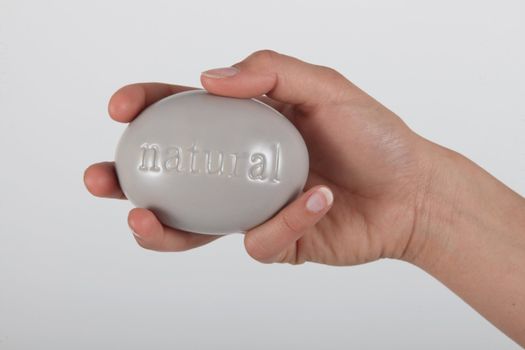 Hand holding soap marked 'natural'