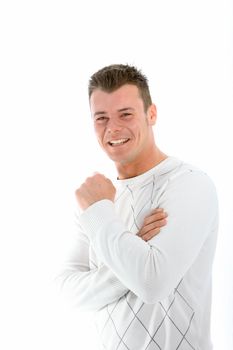 Laughing handsome young man in a winter top standing with his arms folded looking at the camera isolated on white