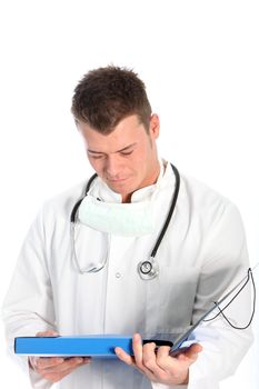 Young male medical doctor in a labcoat with a stethoscope around his neck standing consulting his notes isolated on white