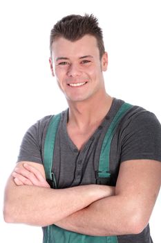 Charismatic genial male artisan or technician standing with his arms folded wearing dungarees grinning at the camera isolated on white