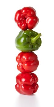 Pepper tower on white background. Three red and one green. Food concept