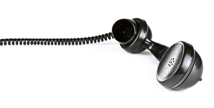 Old black telephone receiver with cord on white background
