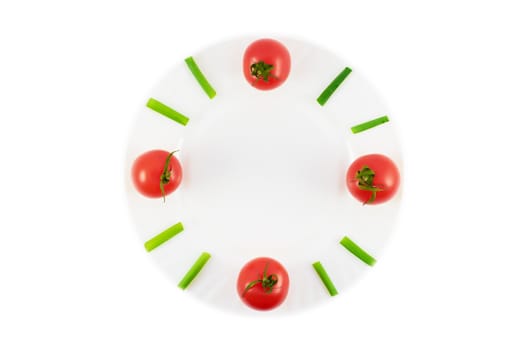 Plate with tomatoes and green onions in a natural clock