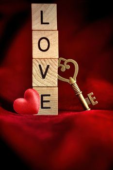 Gold key with wooden block letters that spell the word love