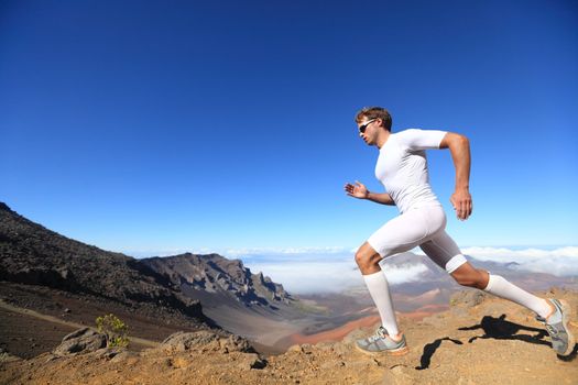 Running sport. Man runner sprinting outdoor in scenic nature. Fit muscular male athlete training trail running for marathon run. Sporty fit athletic man working out in compression clothing doing sprint.
