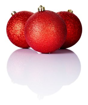Three red christmas baubles on white background with copy space