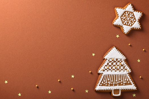 Christmas gingerbreads composition with golden stars and balls on brown paper background