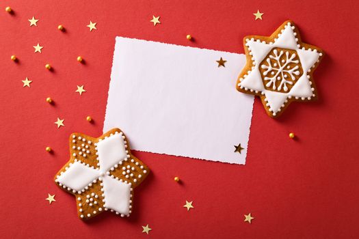 Christmas greeting card with gingerbreads, gold stars and balls. Top view