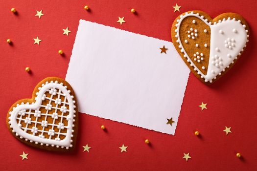 Christmas greeting card with gingerbread hearts, gold stars and balls. Top view