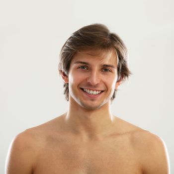 Young beautiful man with naked torso isolated over white background